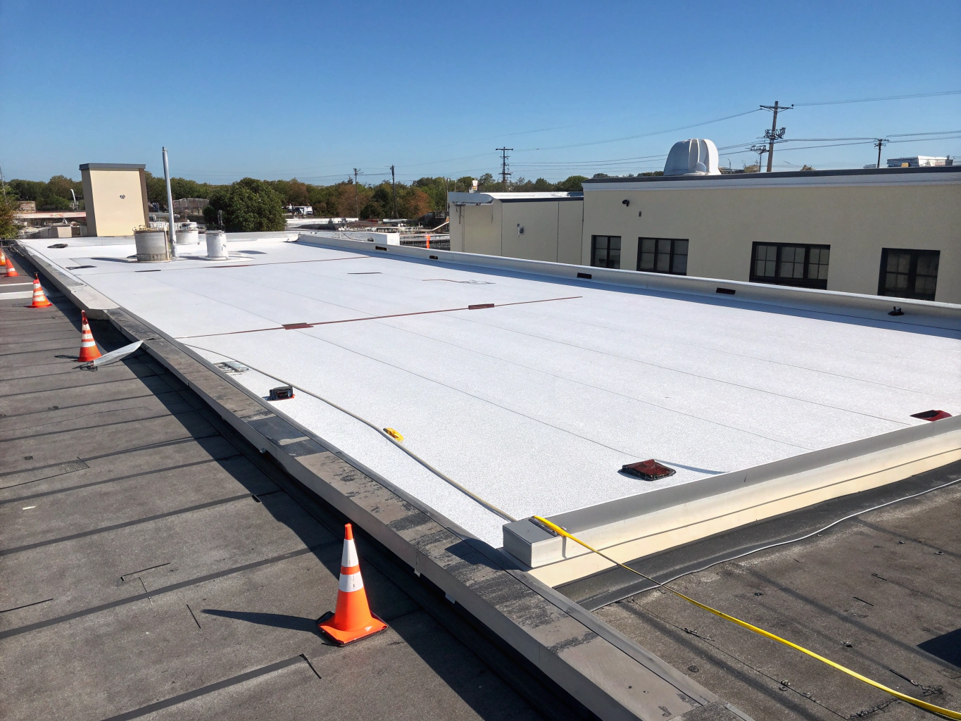 Clean white TPO commercial membrane roof with new scupper drains