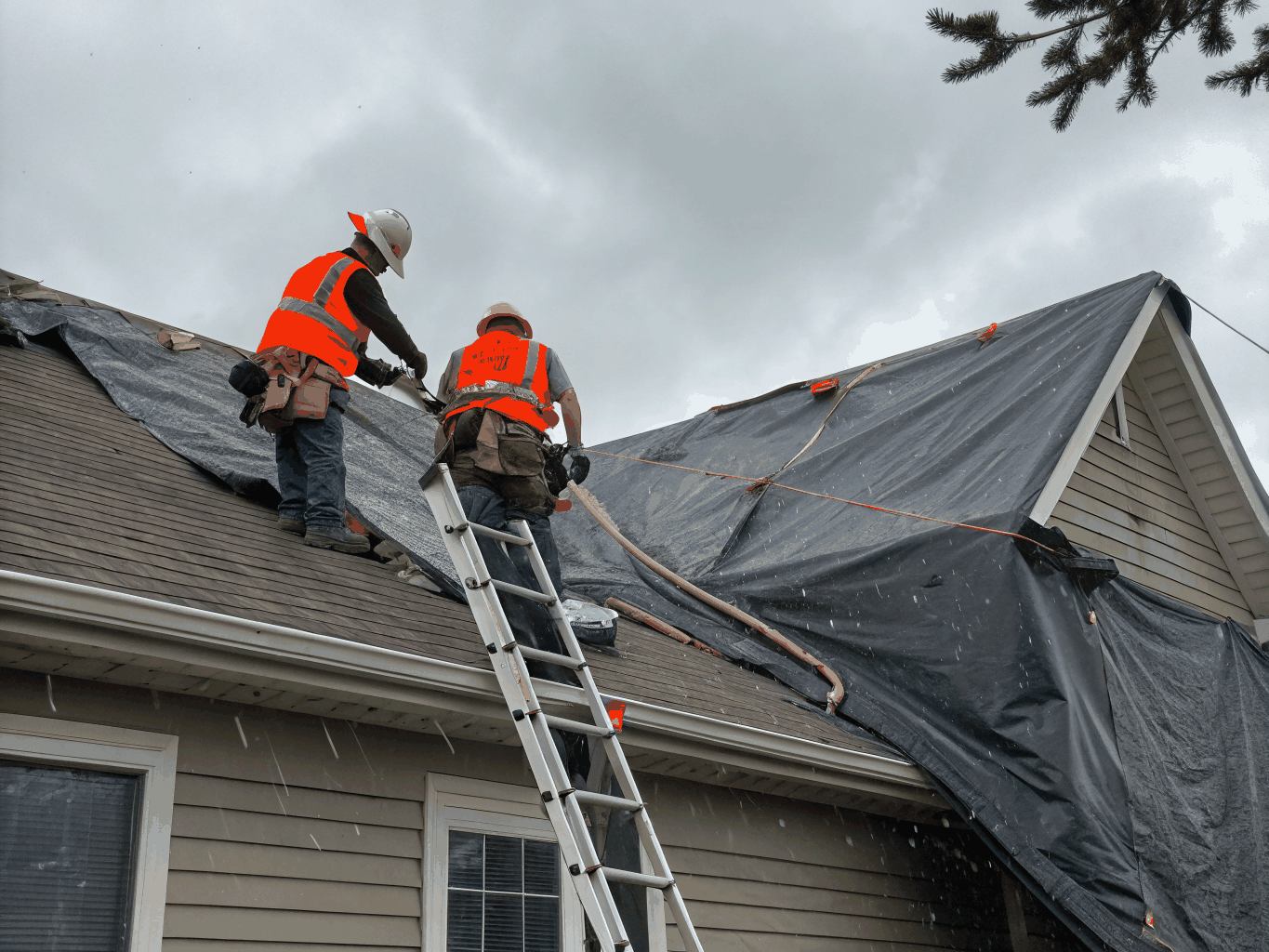 Emergency roofing crew securing heavy-duty waterproof tarps over damaged roof section