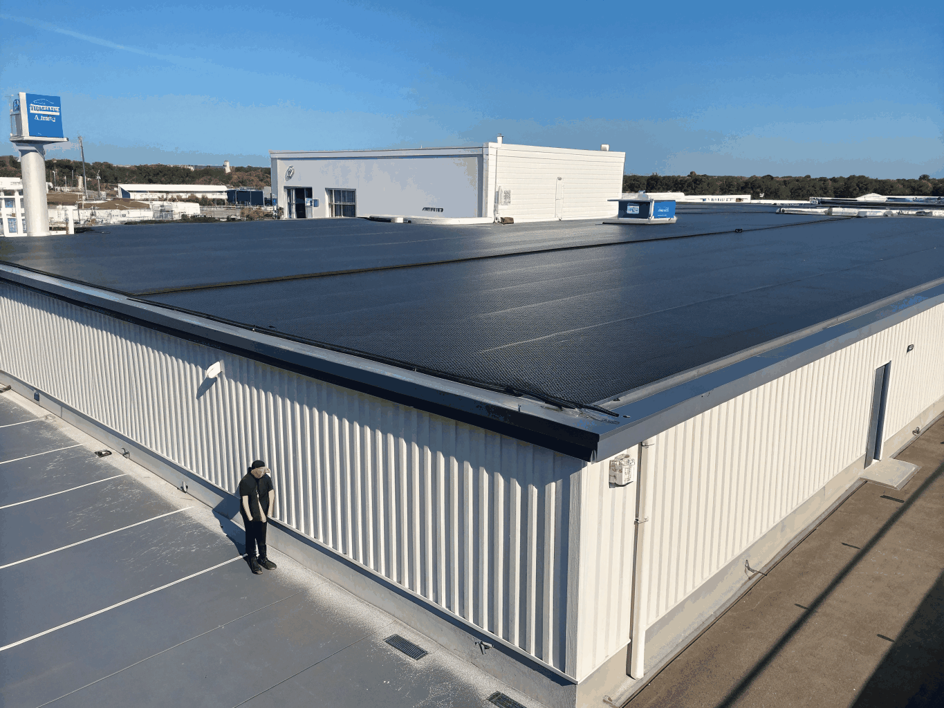 Clean commercial building white TPO flat roofing system with rooftop drainage