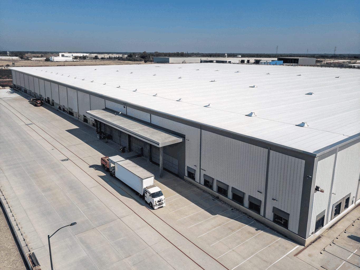 Large commercial flat roof with heat-welded white TPO single-ply membrane