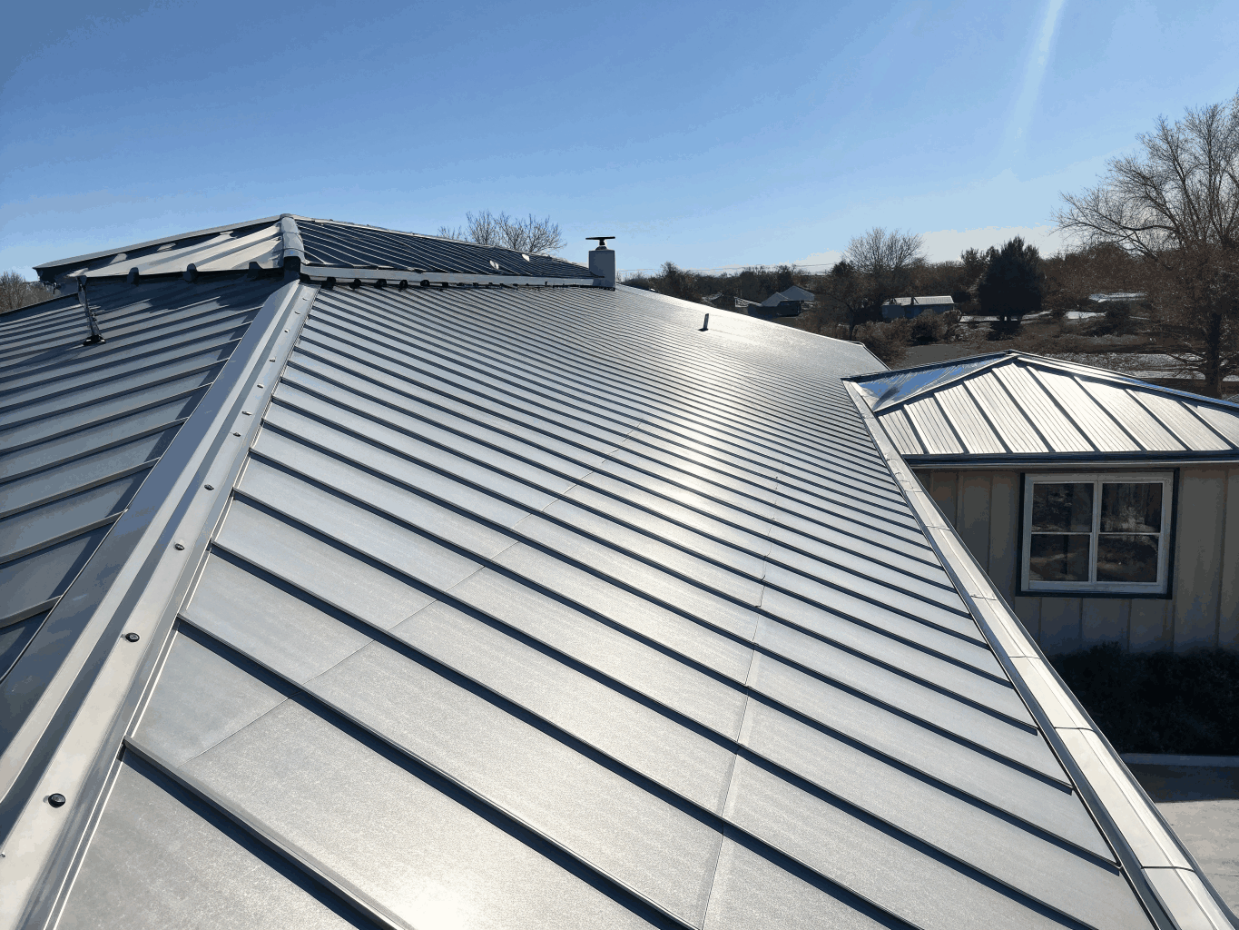 Contemporary residential home with custom dark charcoal standing seam metal roofing