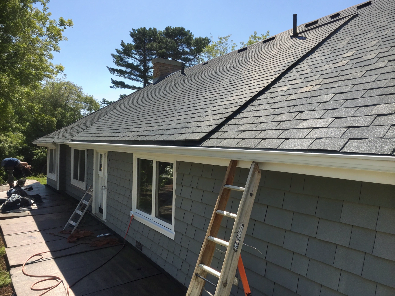 Restored residential roof following storm repair and shingle replacement