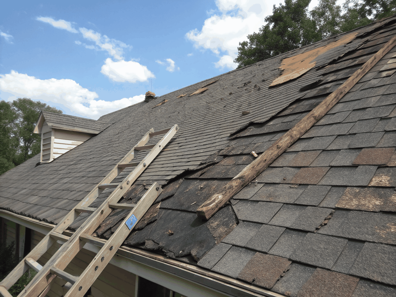 Aged deteriorating shingles on residential roof before replacement